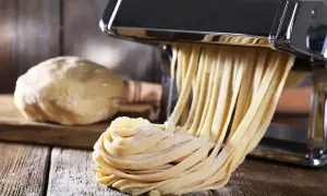 Domowy makaron jak u babci, świeżo wyciskany przez maszynkę. Ciasto czeka na swoją kolej.