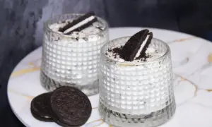 Dwa pyszne mini deserki oreo w szklankach, udekorowane połówkami ciastek. Idealne na deser.