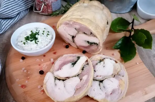 Pyszna galantyna z kurczaka, pokrojona w plastry, podana z kremowym sosem. Idealna na elegancki obiad.